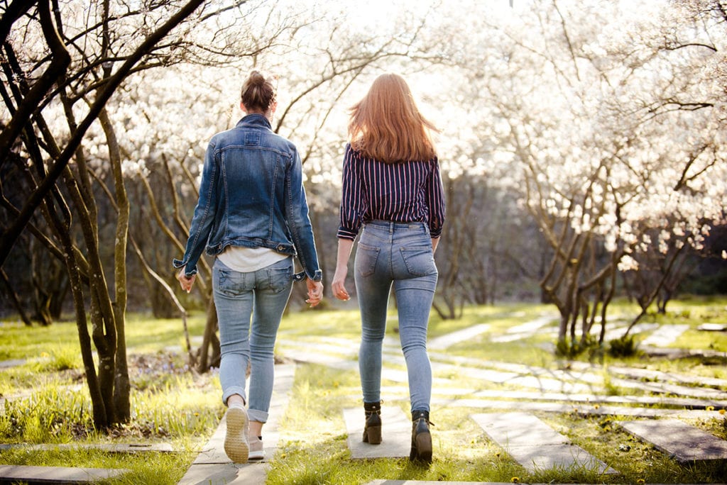 two women walk in a park asking are there benefits of therapy away from home