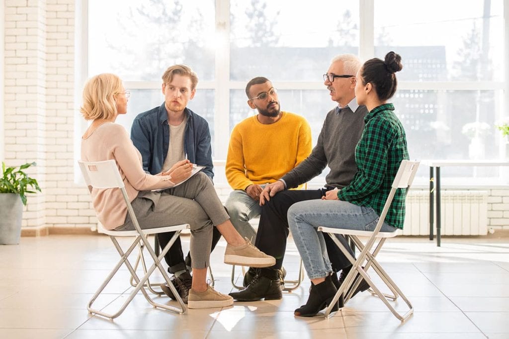 men and women sitting during group therapy activities