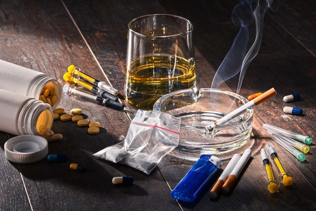 Drug supplies and alcohol lie on a table, symbolizing the myths about drugs