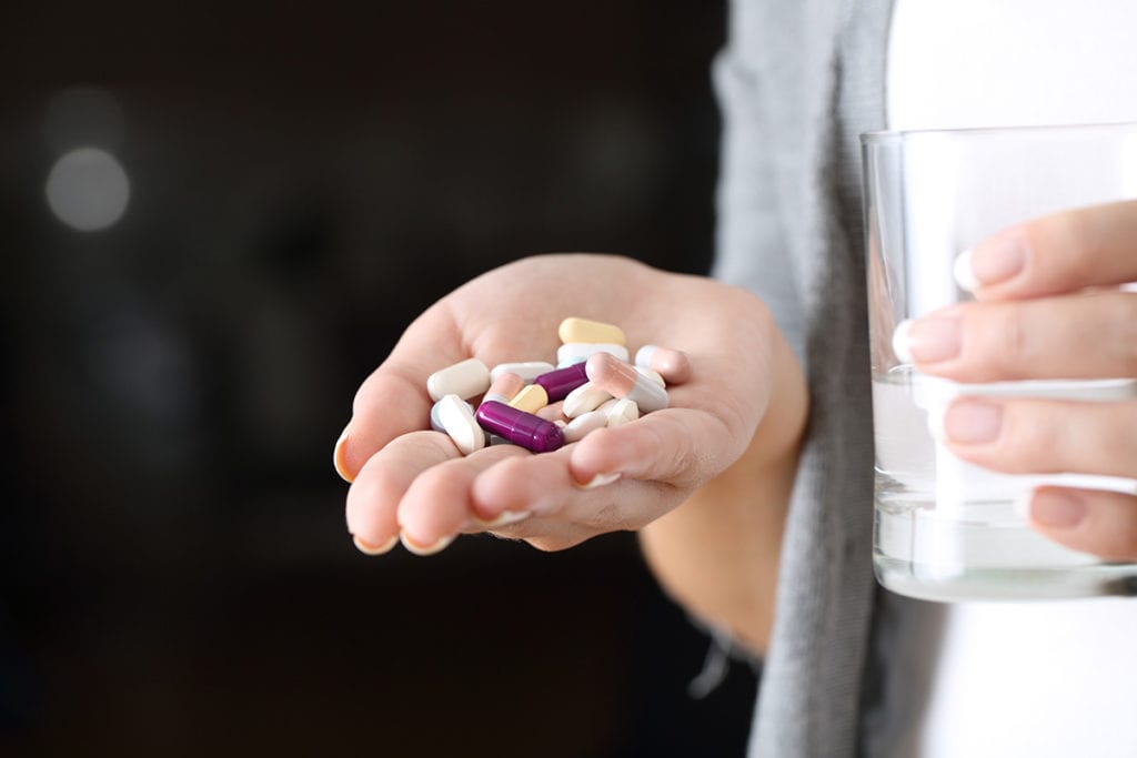 individual holding pills and showing signs of addiction