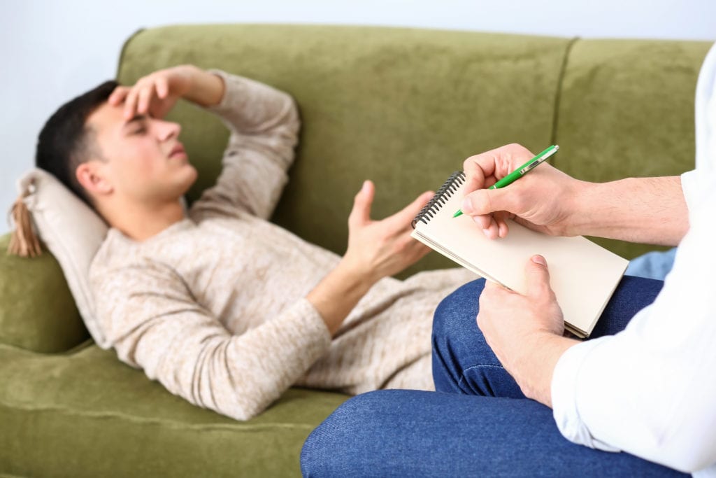 a man on a couch wonders do i need dual diagnosis treatment